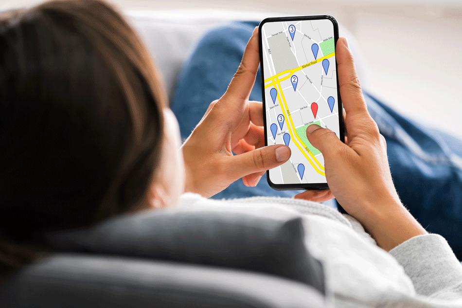 Recherche d'un bien immobilier avec un smartphone, confortablement installé dans son canapé