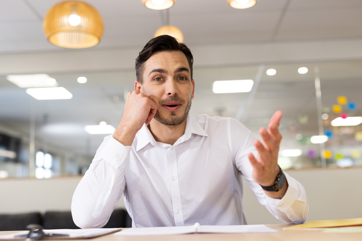 Un homme en chemise blanche nous parle en face à face