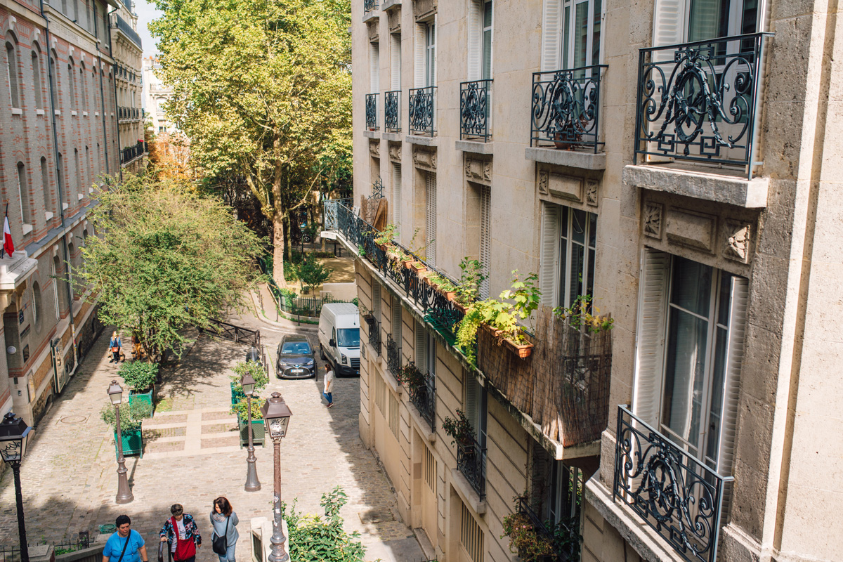 Vue d'une rue de Paris depuis le balcon d'un immeuble haussmannien