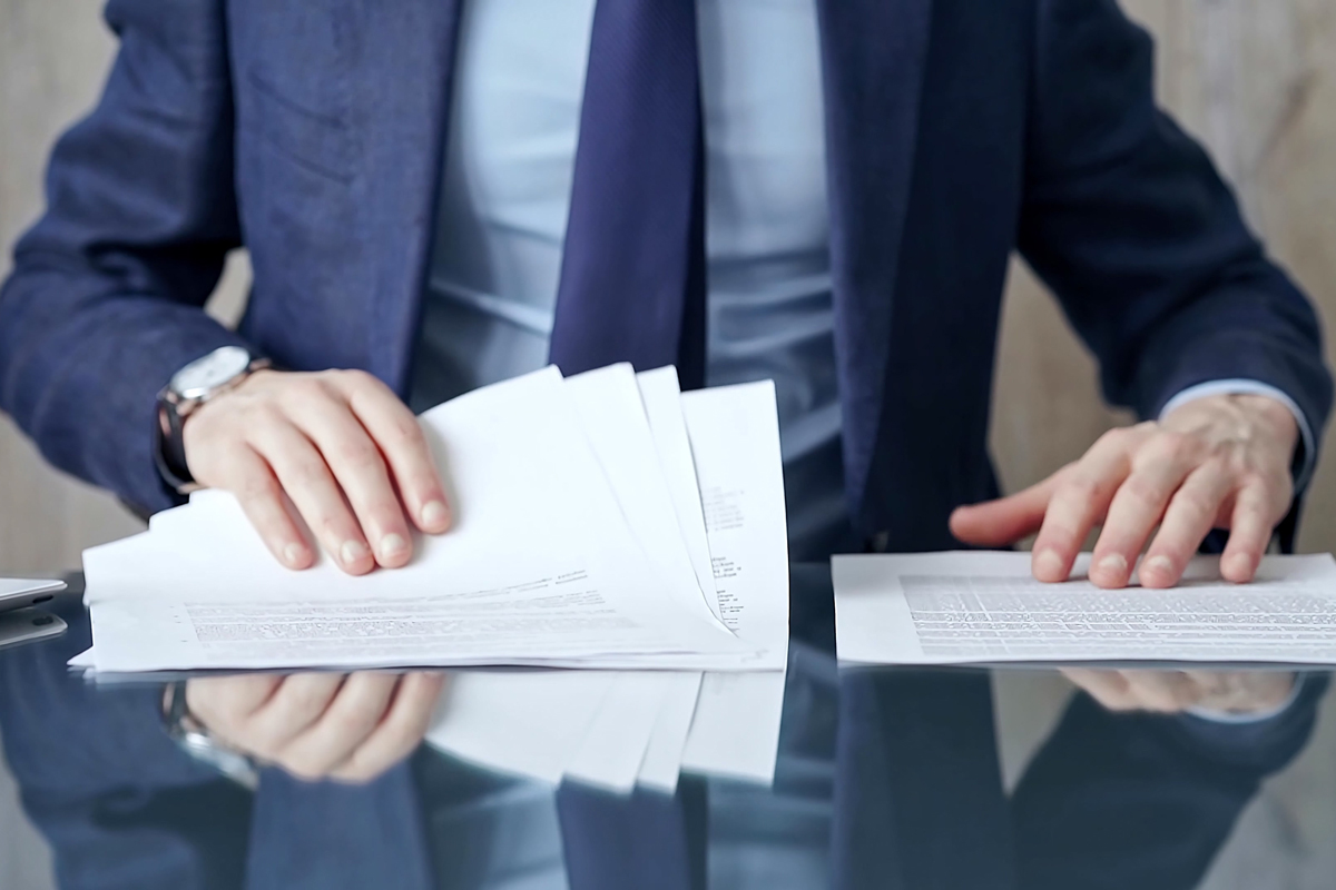Un homme en costume prend connaissance de différents contrats