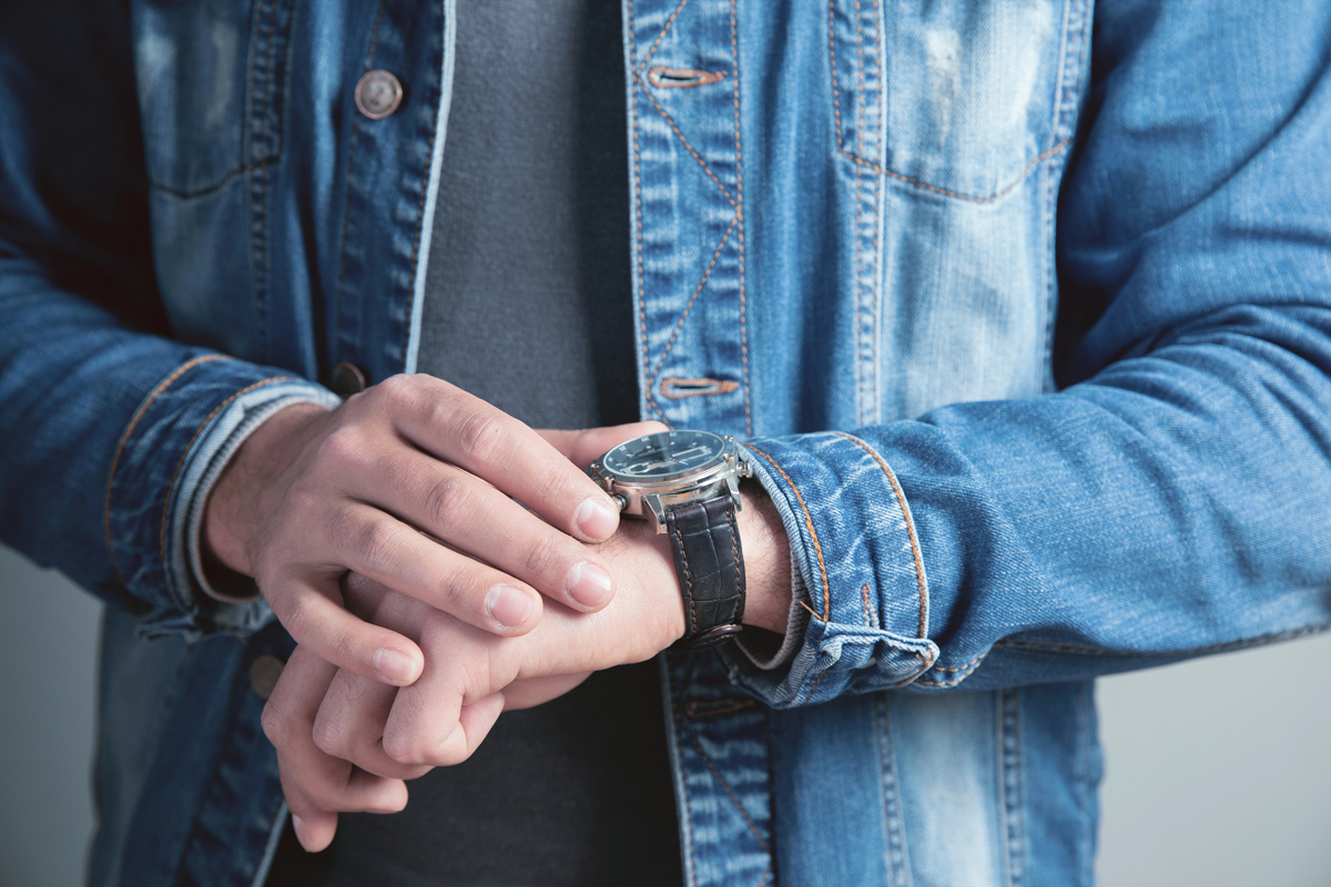 Une personne consulte sa montre, symbolisant les questionnement sur la durée du prêt pour un investissement locatif