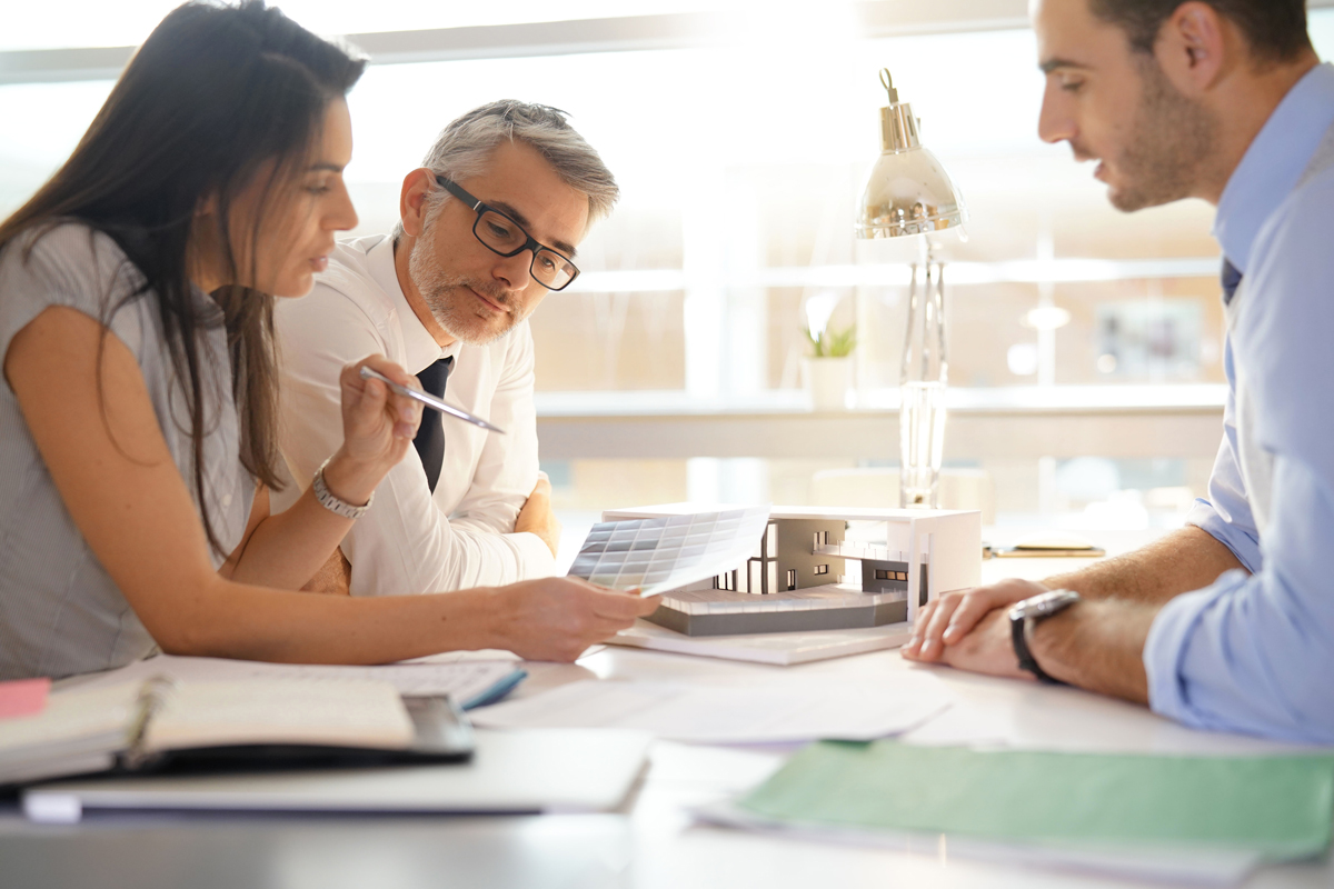 Un couple signe un contrat pour un prêt immobilier infine afin de financer leur investissement locatif