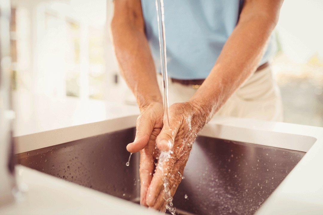 Homme se lavant les mains dans un évier