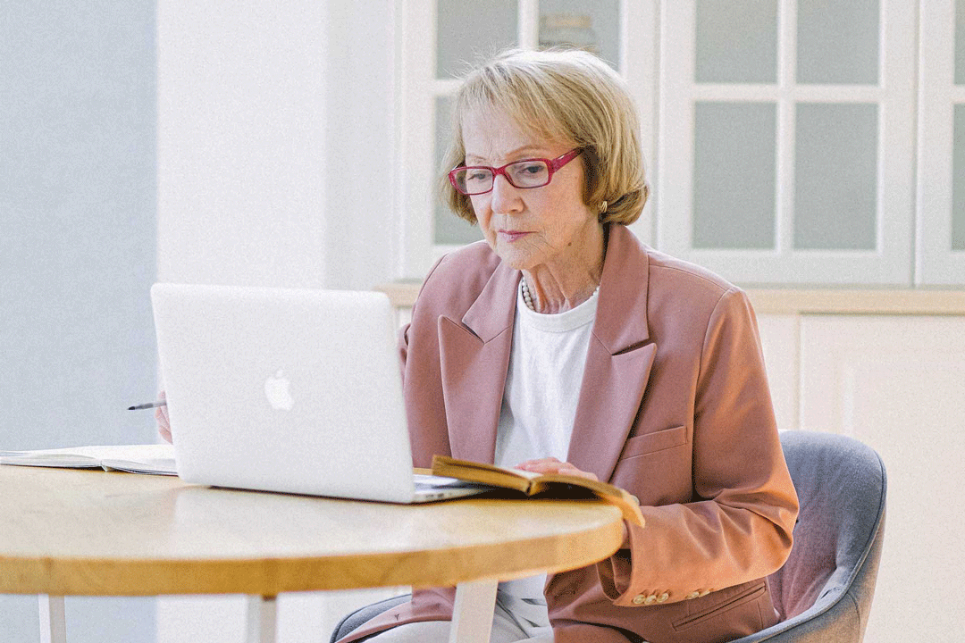 Personne âgée préparant sa retraite à l'aide de son ordinateur