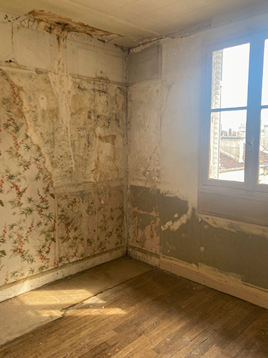 Chambre avant les travaux de rénovation mais où la cuisine a déjà été déposée. On voit les traces de mobilier et du papier peint qui a été déposé.