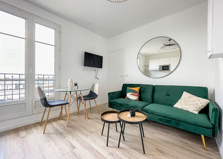 Intérieur d'un appartement moderne et lumineux avec un canapé en velours vert