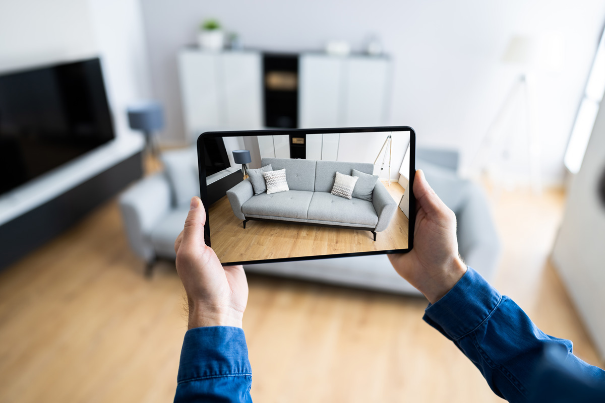 Une personne tenant une tablette prend des photos d'un salon