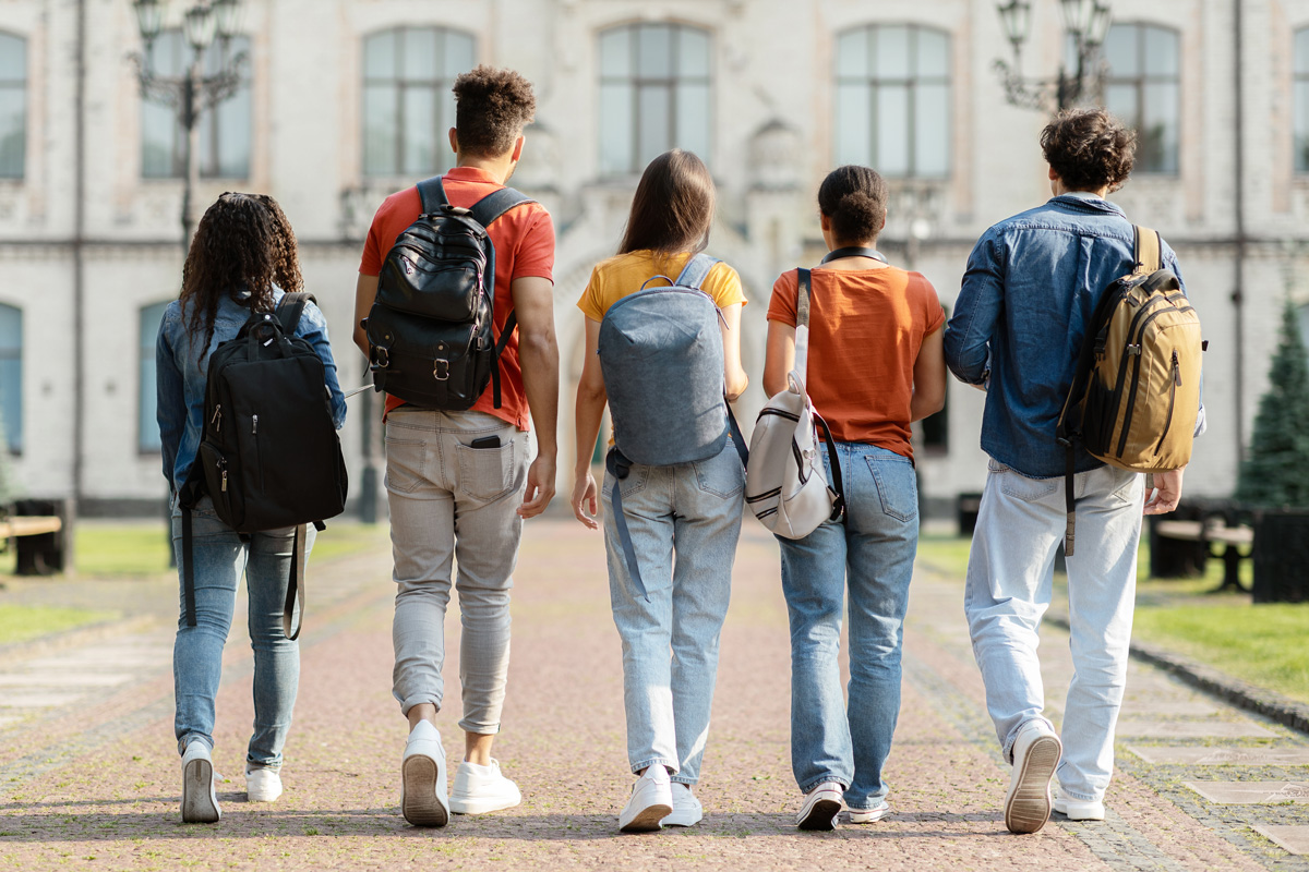 Vue arrière d'un groupe d'étudiants marchant sur un chemin en briques