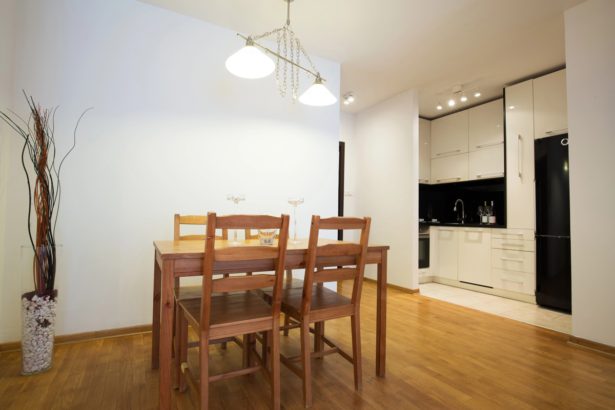 Appartement moderne avec un sol en bois, des murs blancs, et du mobilier conforme au exigences du statut LMNP.