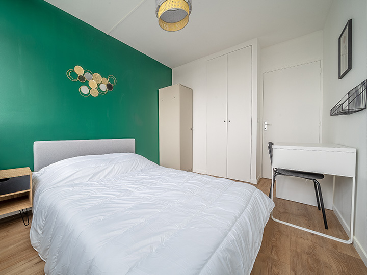 Chmabre rénovée avec une peinture vert pour apporter des touches pop dans cette décoration rétro avec des objets métalliques noirs et dorés.
