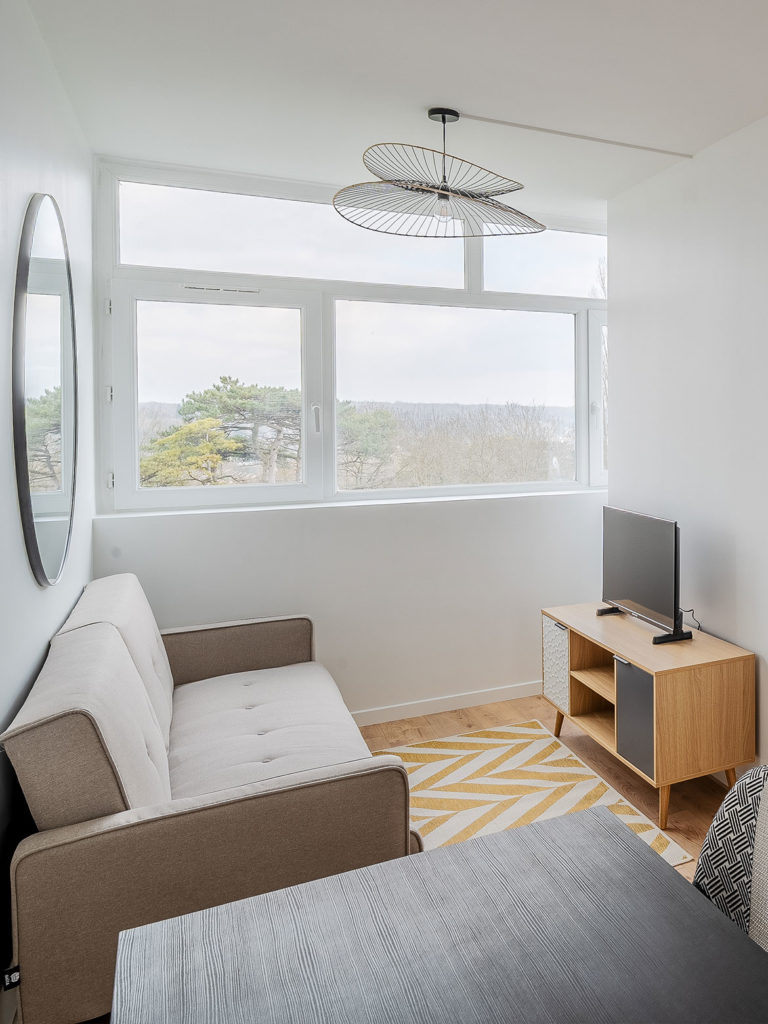 Séjour rénové dans un style scandinave avec beaucoup de lumière et de grandes baies vitrées
